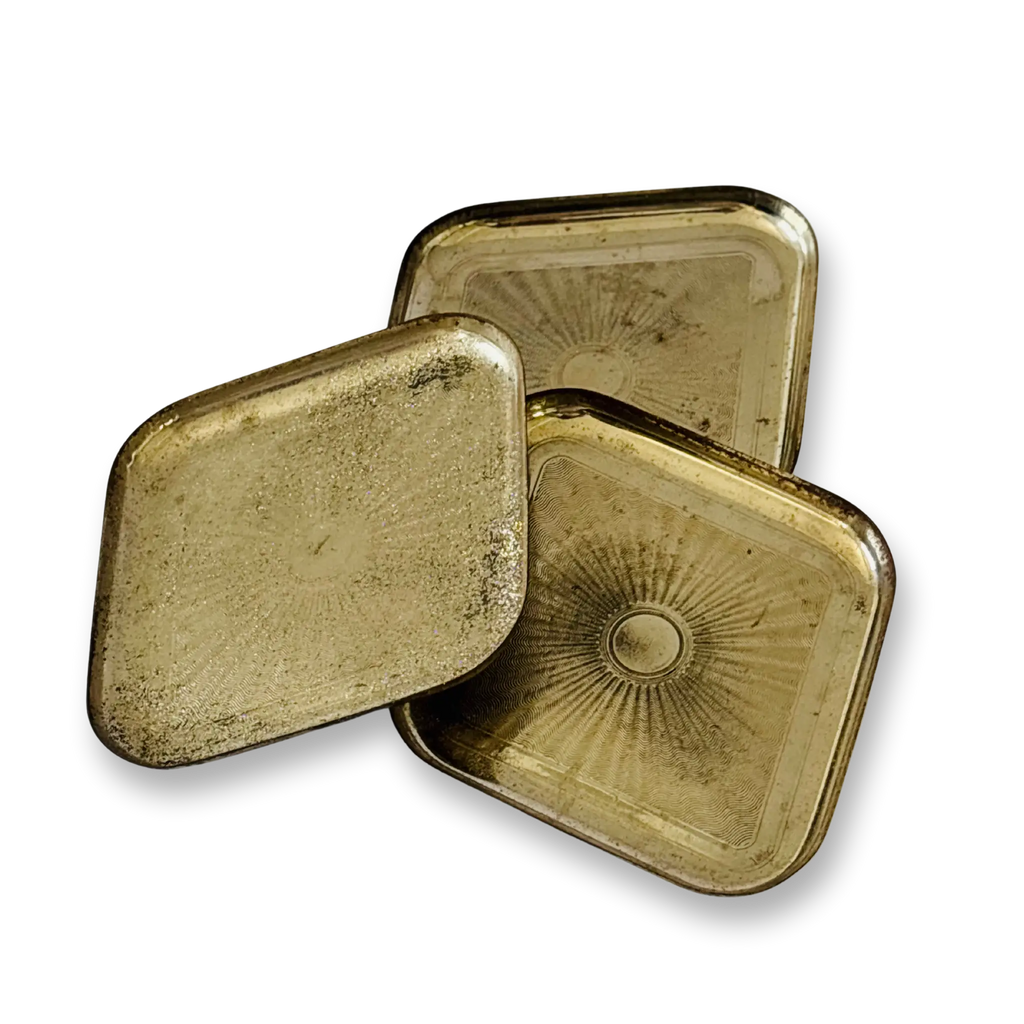 Three Vintage brass trinket platter brass tins with sunburst designs on a white background